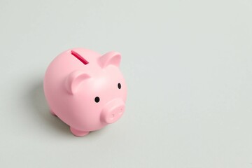 Piggy coin bank on gray background for money savings, financial security or personal funds concept