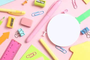Flat lay with school stationery with paper card on pink background, top view