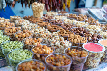 A variety of nuts at a street market in plastic containers
