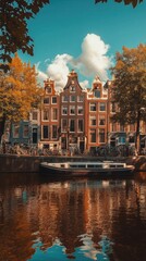 Obraz premium Historic canal bridge in Amsterdam, Netherlands, with bicycles lined up along the water and golden autumn trees framing a picturesque view of traditional Dutch gabled houses in the city.