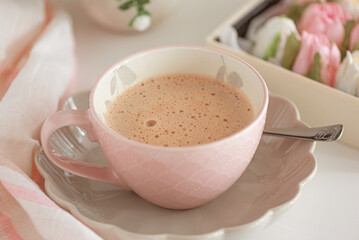 Hot chocolate in pink mug  and tulip flower shaped marshmallows.