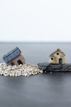 Two miniature houses in sand and rock. Copy space. Close-up. Gospel parable of Jesus Christ for obedience and faith in God. Christian concept.