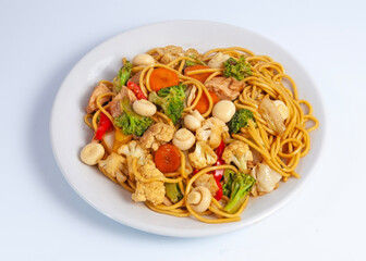 Japanese yakisoba noodles with vegetables and meat circular white plate white background
