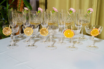 Elegant drinkware arranged on a table with citrus slices and flowers, perfect for a celebration setting
