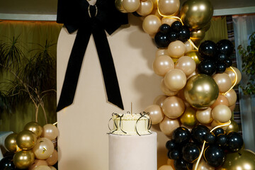 Elegant celebration setup featuring a festive cake and decorative balloon arch