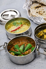 A retro Indian lunch box filled with vegetarian food. And chapati.