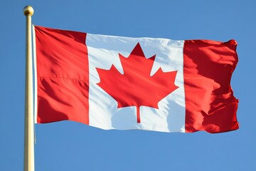 Flag waving proudly in the clear blue sky representing Canadian heritage and identity