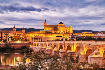 Illuminated Mezquita Cathedral and Roman Bridge in Cordoba at Sunset, Andalusia