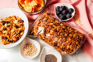 Healthy breakfast ingredients with handmade granola and fruits mango, papaya and grapes