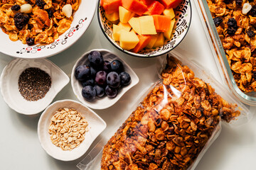 Healthy breakfast ingredients with handmade granola and fruits mango, papaya and grapes