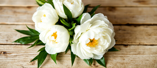 Fototapeta premium close-up view of three white peonies arranged on rustic wooden surface