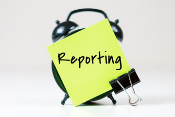 Reporting inscription on paper with alarm clock