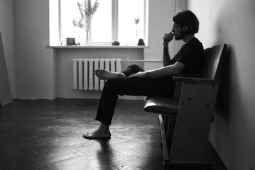 young man sitting on a chair and thinking