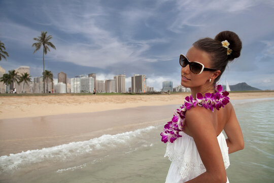  Young Woman Embraces Waikiki&rsquo;s Beauty with Traditional Hawaiian Lei