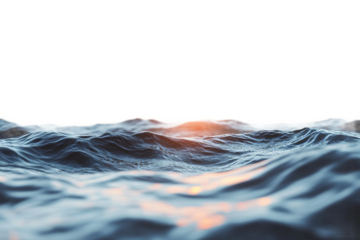 Waves gently rolling under a bright sunset sky