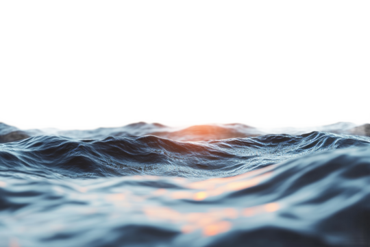 Waves gently rolling under a bright sunset sky