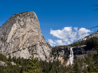 Heavenly clouds above mountain and tree views in Yosemite.
