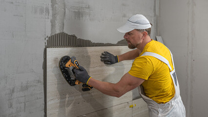 Tiling with large format tiles. A tiler expelling air from under the tile by a vibration suction...