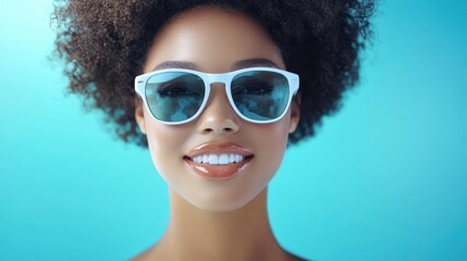 Fototapeta premium A woman wearing sunglasses poses against a vibrant blue background, exuding confidence and style.