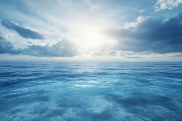 Ocean waves reflect sunlight and clouds during a serene morning at sea