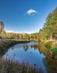 Obraz premium Calm river with a blue sky in the background