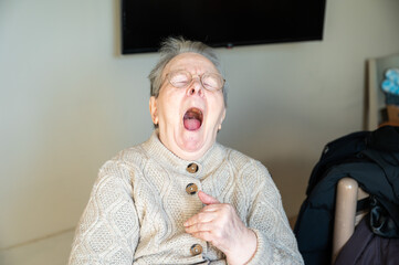 Expressive portrait of an 86 yo grandmotheryawning in Tienen, Flemish Brabant, Belgium