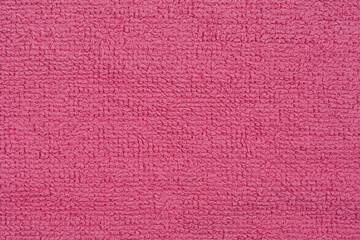 A close-up shot of a pink terry cloth fabric reveals its textured, looped surface, highlighting its soft and plush nature