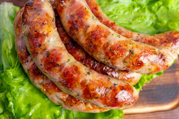 Delicious grilled sausage resting on fresh lettuce leaves