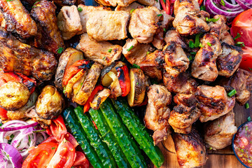Grilled meat and vegetables arranged on a wooden table display