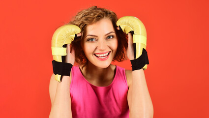Smiling boxer woman in boxing gloves before training. Fitness sporty girl ready for fight. Winning,...