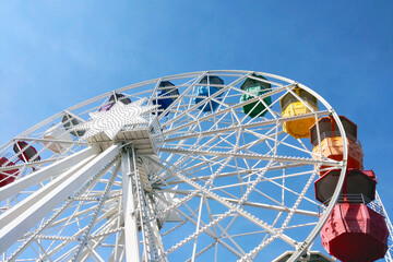 Colorful Ferris Wheel Against a Clear Blue Sky for Summer Amusement Park Designs