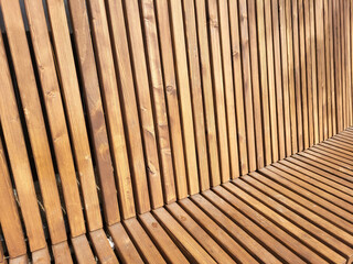 Brown bench with a high back made of narrow slats