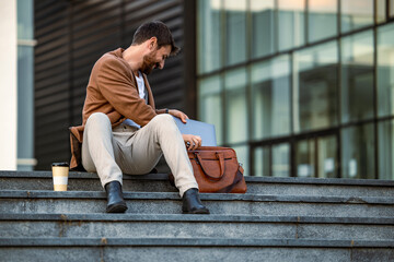 Businessman Sitting on Steps with Briefcase and Coffee