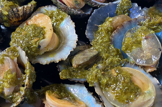 Grilled limpets Lapas grelhadas served with lemon close up. Traditional dish of Portugal and a typical snack of the Canary Islands.Seafood concept.
Selective focus.