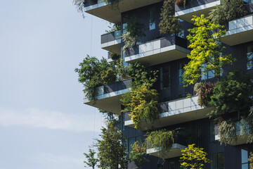 Residential tower, an example of modern architecture with various plants and tree-covered...