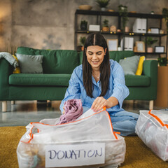 One woman caucasian adult at home choose clothes for charity donation