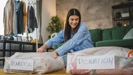 One woman caucasian adult at home choose clothes for charity donation