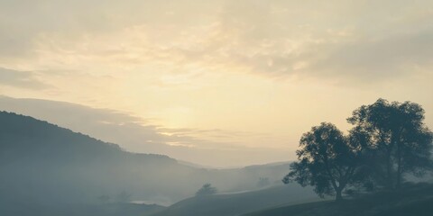 Obraz premium Serene landscape with misty hills and soft sunrise glow over distant trees