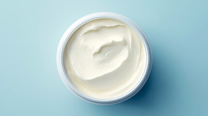 Creamy cheese bliss revealed from above in a sleek container against a soft blue background