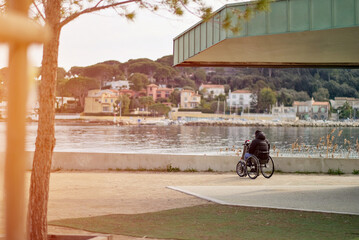 Disabled Person In The Wheelchair Outdoors Enjoying The Spectacular View Of Marine Bay