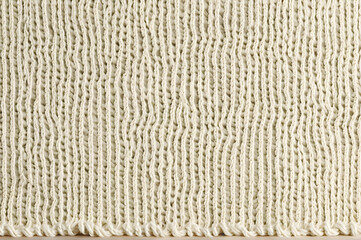 Nahaufnahme von gestricktem, cremefarbenem Stoff