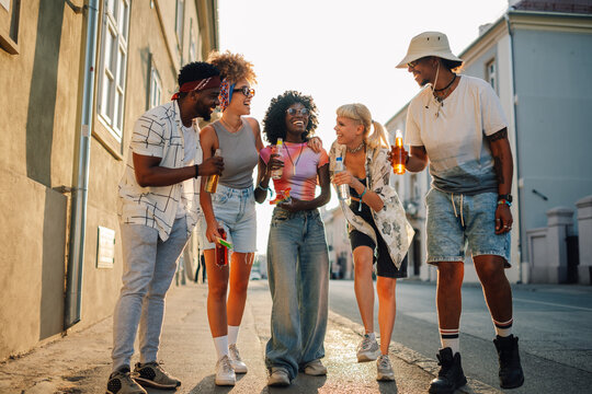Group of diverse friends enjoying drinks and laughter on city street