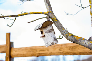 Wooden birdhouse hanging on a tree
