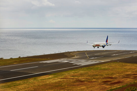 FUNCHAL - MARCH 24: View of runway with landing plane in Cristiano Ronaldo International Airport in Funchal, Madeira island, Portugal