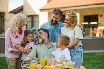 Happy family enjoying weekend brunch together in backyard