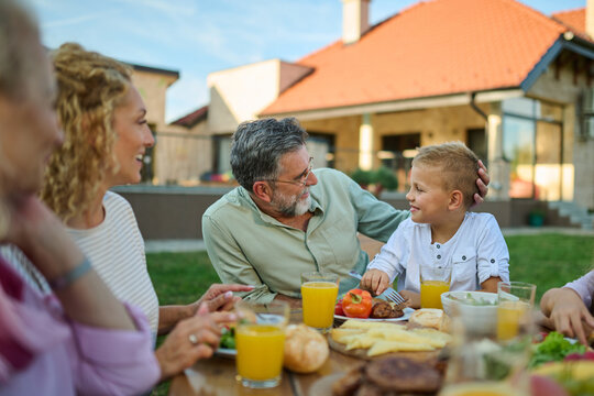 Happy family enjoying meal together at outdoor table on a sunny day