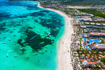 Aerial view of Bavaro beach Punta Cana tropical resort in Dominican Republic. Beautiful atlantic tropical beach with palms, umbrellas and parasailing balloons