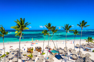 Aerial drone view of beautiful caribbean tropical beach with palms and straw umbrellas. Bavaro,...