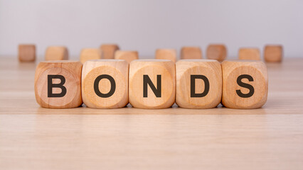 the text BONDS is written on wooden blocks on a brown background