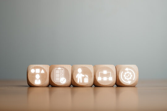 Wooden blocks depicting the 5S methodology icons for improving workplace organization and efficiency.